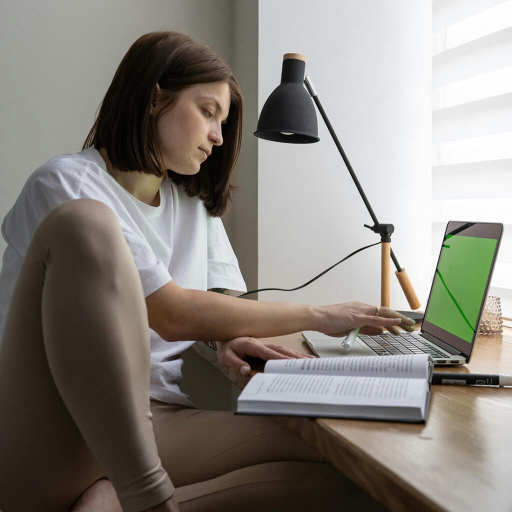 Mujer de perfil usando notebook en escritorio